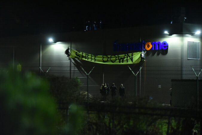gorßes Banner shutdown an der Fassade der Atomfabrik, das Logo Framatome ist zu sehen, es ist Nacht